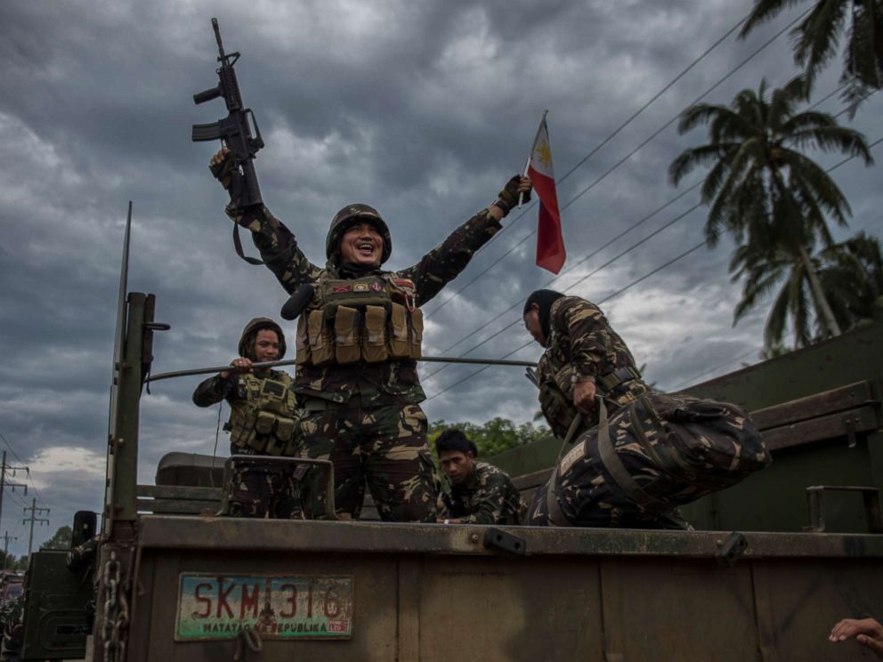 PHOTO: A government soldier waving the Philippine flag as they get ready to leave the battle against IS-inspired militants, Oct. 20, 2017, in Saguiaran town in Lanao del Sur, southern Philippines.