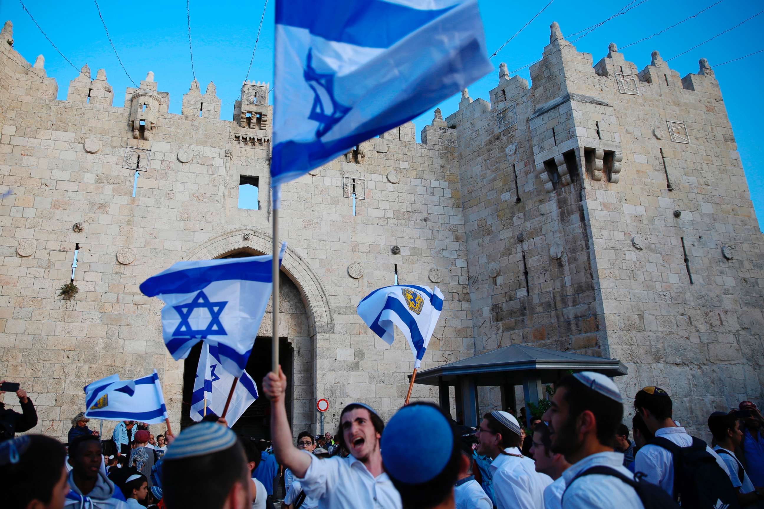 PHOTO: Israelis wave national flags outside the Old City's Damascus Gate, in Jerusalem, May 13, 2018.