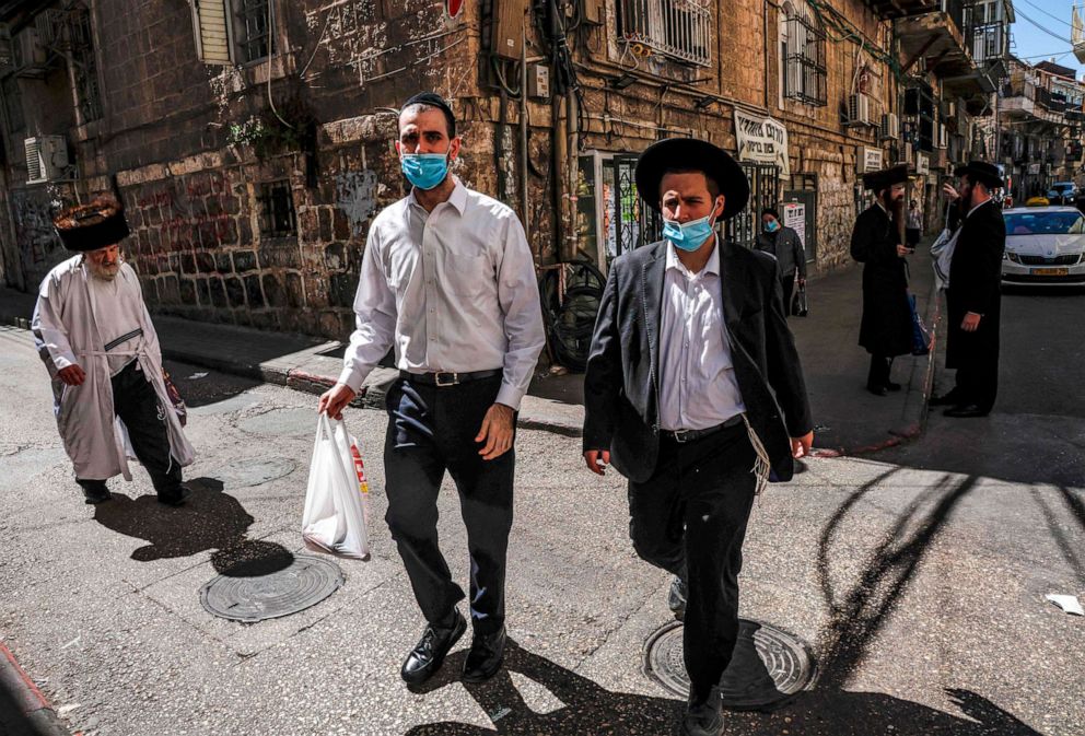 PHOTO: Ultra-Orthodox Jews, mask-clad due to the COVID-19 coronavirus pandemic, walk along a street in the neighborhood of Mea Shearim Jerusalem a few hours before the start of Yom Kippur, the Jewish holy day of Atonement, Sept. 27, 2020. 