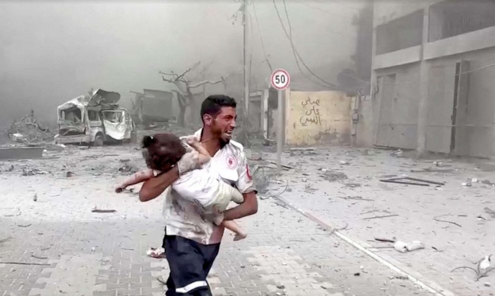 PHOTO: A medic runs as he carries an injured Palestinian child to ambulance in this screengrab taken from a video, in Gaza, Oct. 9, 2023.