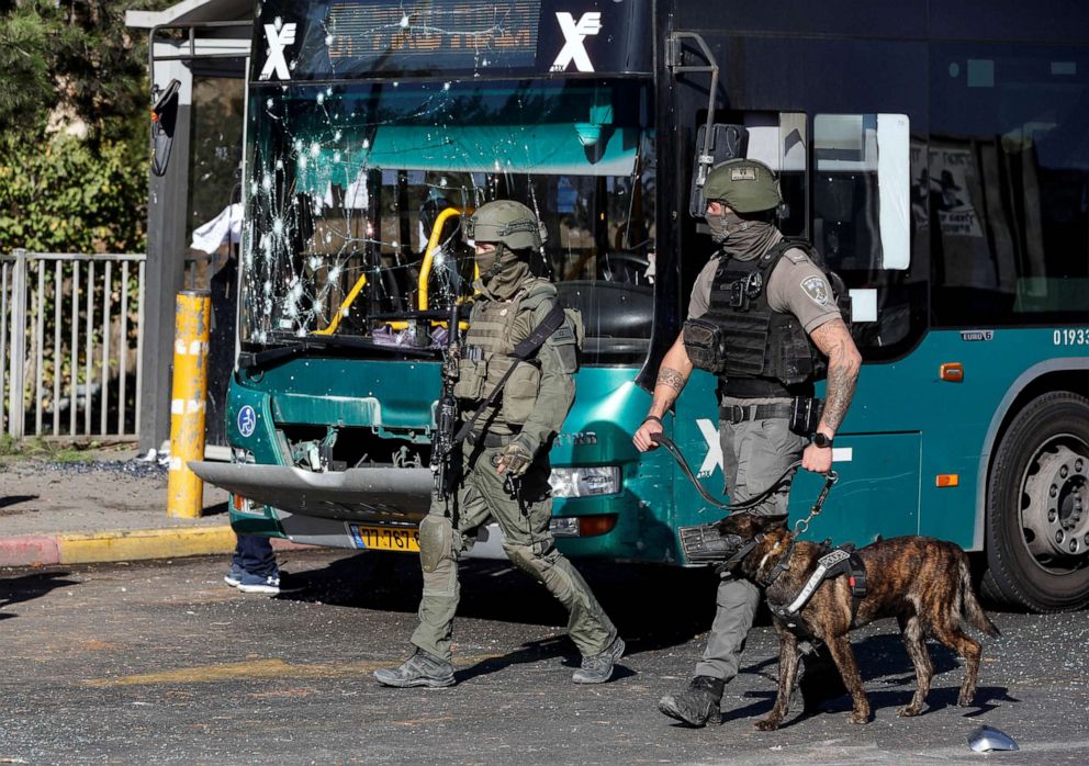 PHOTO: Israeli border police walk past a damaged bus following explosions in Jerusalem Nov. 23, 2022.