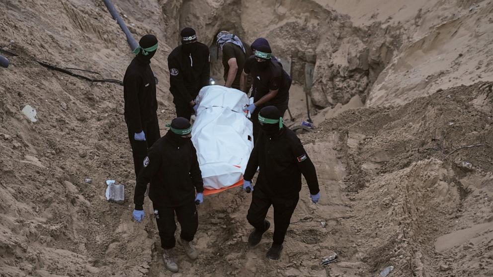 PHOTO: Hamas militants carry a white bag believed to contain a body, after retrieving it from a tunnel during a search for the remains of hostages in Hamad City, Khan Younis, in southern Gaza, Oct. 28, 2025. 