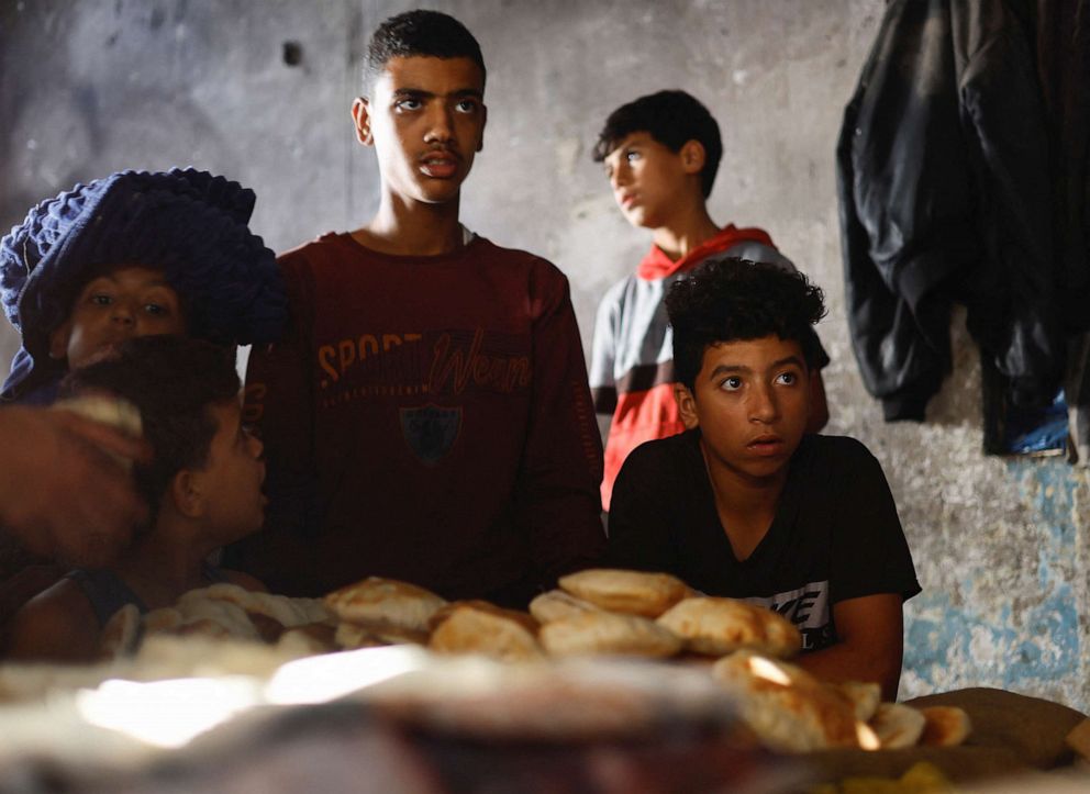 PHOTO: Palestinians wait for bread baked on firewood, amid fuel and power shortages in Khan Younis in the southern Gaza Strip, Oct. 16, 2023.