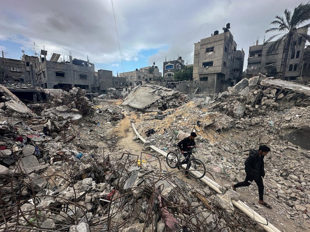 PHOTO: Palestinians walk among the rubble, as they inspect houses destroyed in Israeli strikes during the conflict, amid the temporary truce between Hamas and Israel, at Khan Younis refugee camp in the southern Gaza Strip Nov. 27, 2023. 