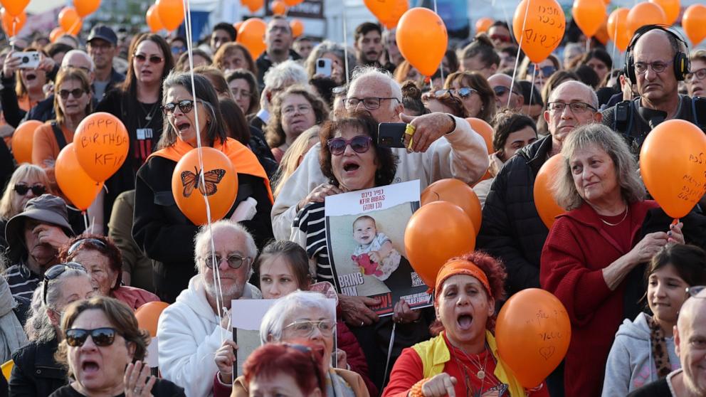 PHOTO: People hold orange balloons as they attend a ceremony to mark the first birthday of Israeli toddler Kfir Bibas, who is held hostage by Hamas in Gaza, outside the Kirya military base in Tel Aviv, Israel, Jan. 18 2024. 