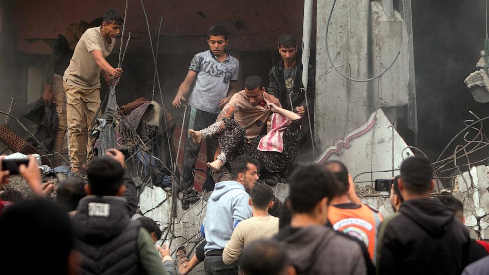 PHOTO: Palestinians rescue a woman from a destroyed building following Israeli airstrikes in Khan Younis refugee camp, southern Gaza Strip, Dec. 7, 2023. 