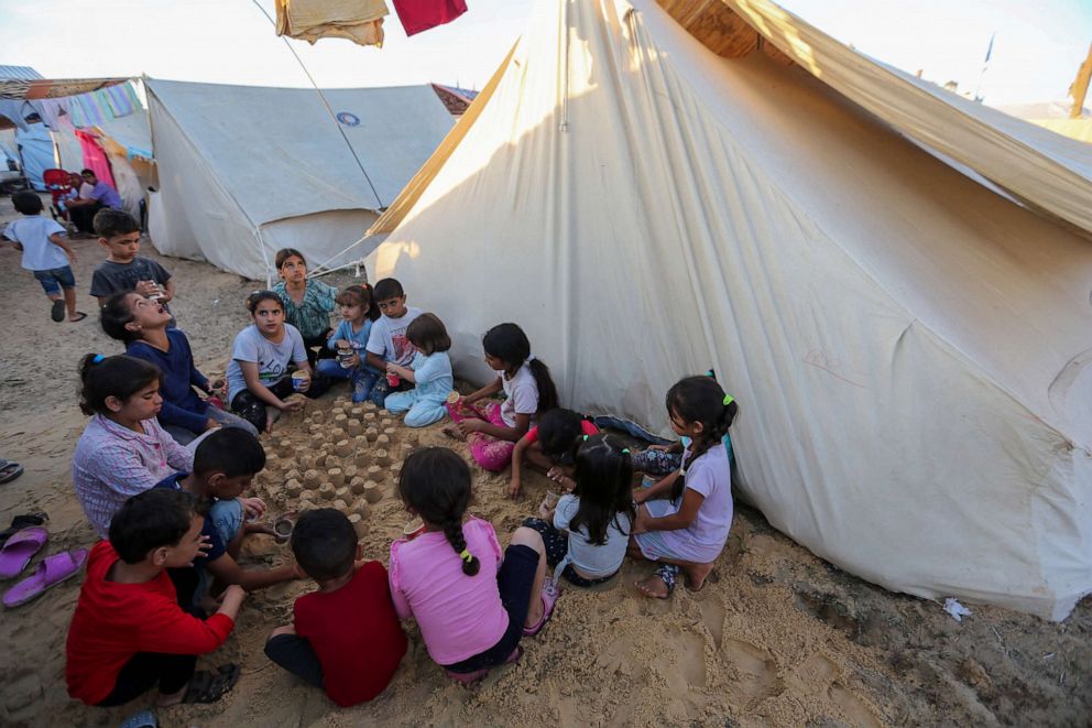 PHOTO: A group of children make sandcastles beside tents at a refugee camp Oct. 26, 2023, in Khan Yunis, Gaza.