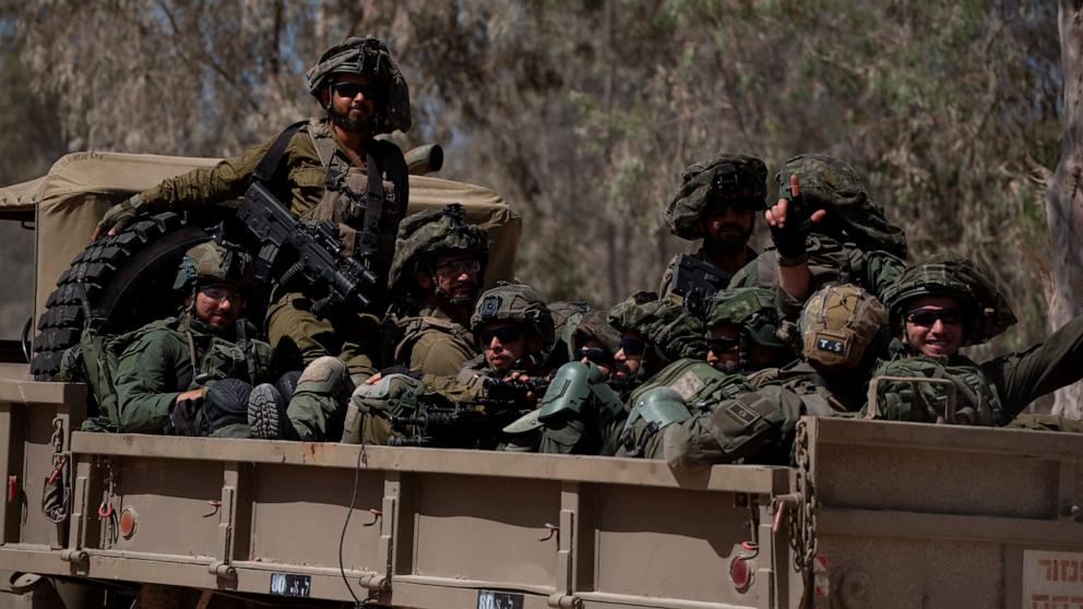 PHOTO: Israeli soldiers move on the back of a truck near the Israeli-Gaza border as seen from southern Israel, June 10, 2024. 