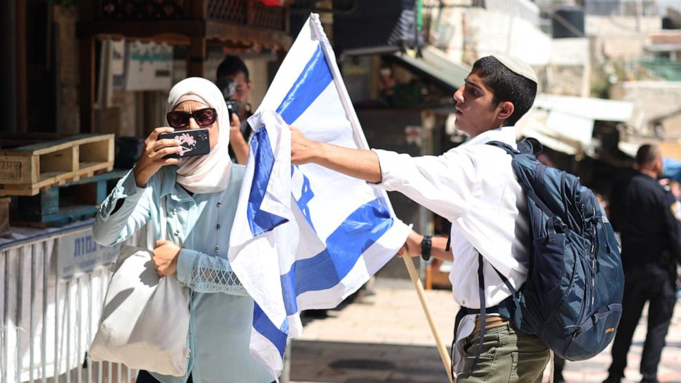 PHOTO: A participant in the 'Flag March' tries to prevent a woman from taking photos in the Old City of Jerusalem, June 5, 2024, as Israel marks its national holiday of Jerusalem Day.