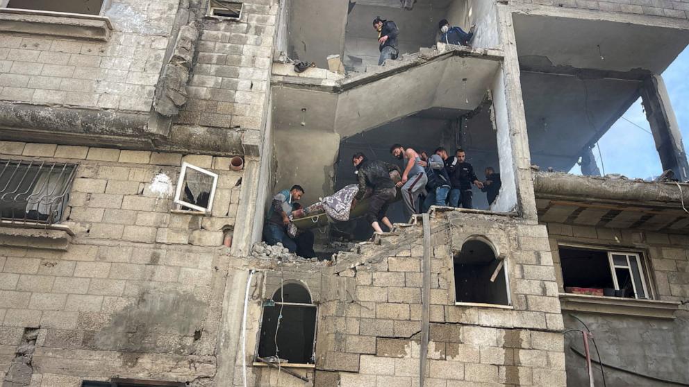 PHOTO: Palestinians carry a woman casualty of an Israeli strike from a house at Maghazi refugee camp in the central Gaza Strip, amid the ongoing conflict between Israel and the Palestinian Islamist group Hamas, Jan. 3, 2024. 