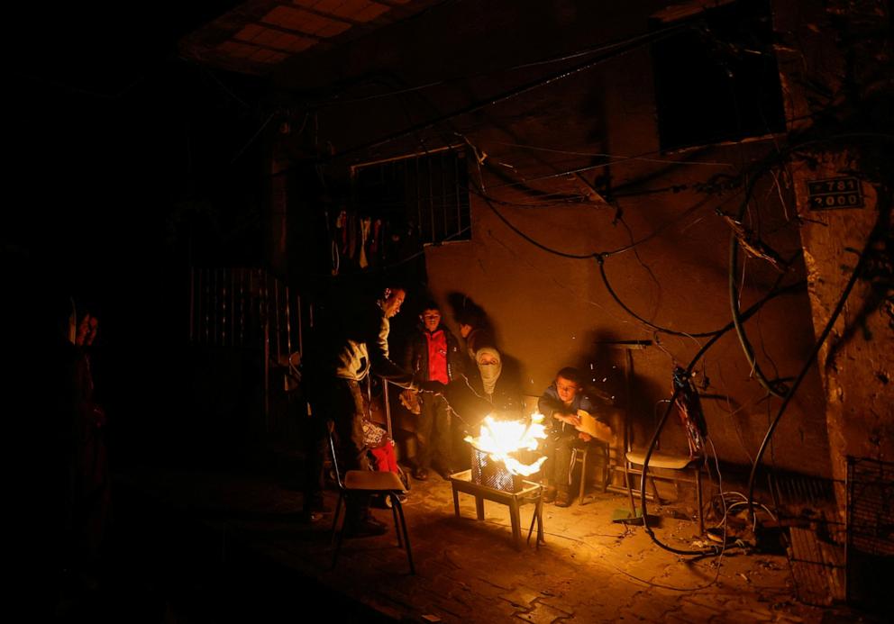 PHOTO: Palestinians sit next to a fire, amid a temporary truce between Hamas and Israel, in Khan Younis in the southern Gaza Strip Nov. 27, 2023.