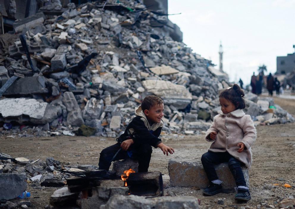 PHOTO: Palestinian children sit by the fire next to the rubble of a house hit in an Israeli strike during the conflict, amid a temporary truce between Hamas and Israel, in Khan Younis in the southern Gaza Strip on Nov. 27, 2023.