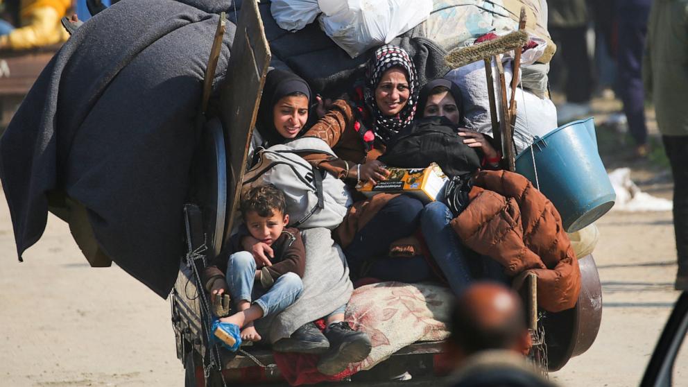 PHOTO: A displaced family rides on the back of a vehicle with their belongings as they cross the Netzarim corridor from the southern Gaza Strip into the northern part on January 27, 2025.