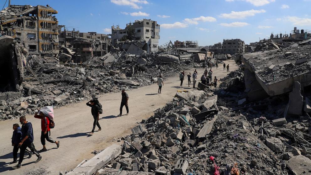 PHOTO: Palestinians walk past the rubble of destroyed buildings, amid a ceasefire between Israel and Hamas, in Gaza City, October 14, 2025.