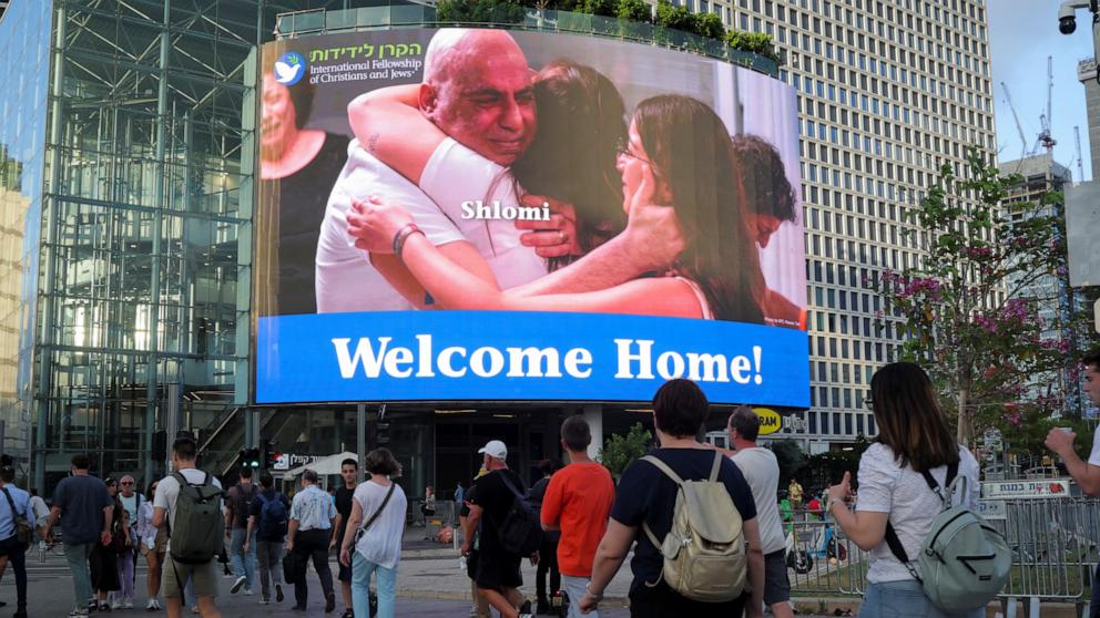 PHOTO: People walk near a screen displaying a picture of Shalom Ziv who was kidnapped during the deadly October 7 attack and, according to the military, rescued by the Israeli forces, in Tel Aviv, Israel June 10, 2024. 