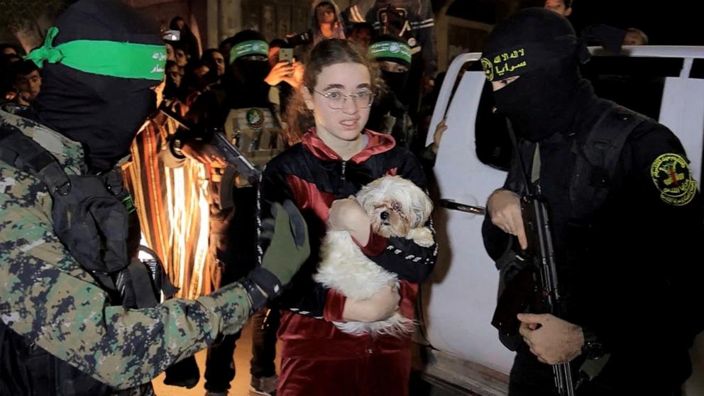 PHOTO: A hostage who was abducted by Hamas gunmen during the October 7 attack on Israel holds a dog while she and others are handed over by Hamas militants to members of the International Committee of the Red Cross in the Gaza Strip, Nov. 28, 2023.