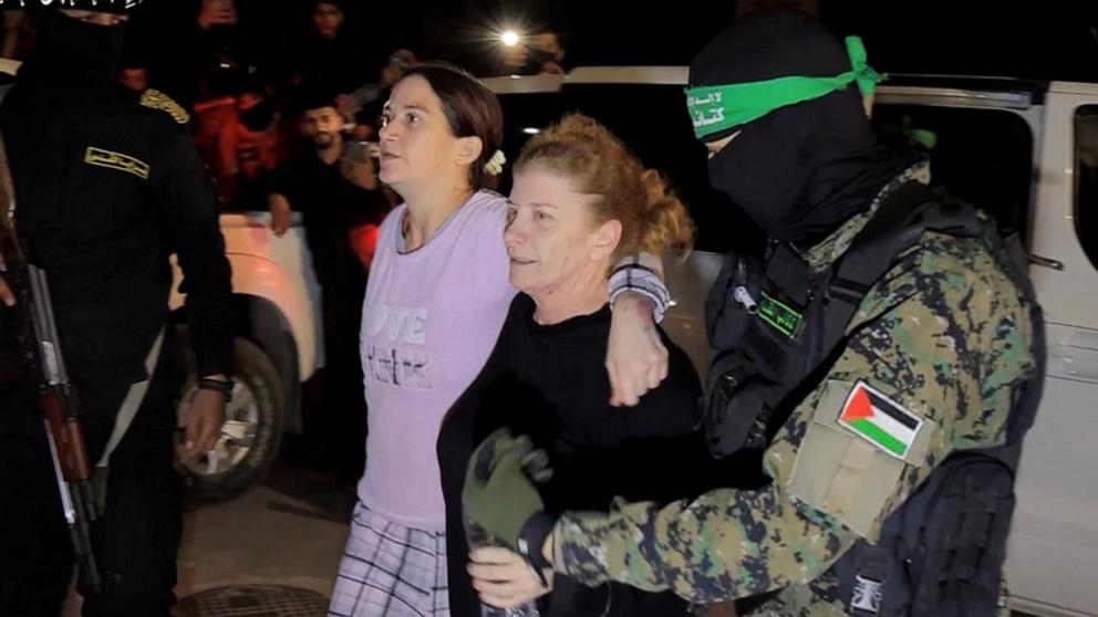 PHOTO: Hostages who were abducted by Hamas gunmen during the October 7 attack on Israel, are handed over by Hamas militants to members of the International Committee of the Red Cross in the Gaza Strip, Nov. 28, 2023. 