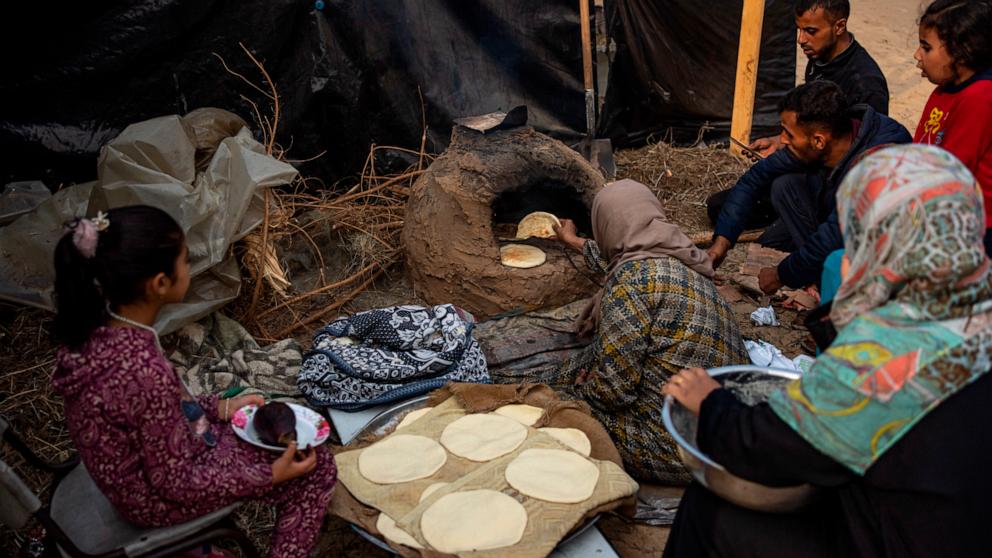 PHOTO: Palestinians displaced by the Israeli bombardment of the Gaza Strip cook at the makeshift tent camp in the Muwasi area, Dec. 28, 2023.