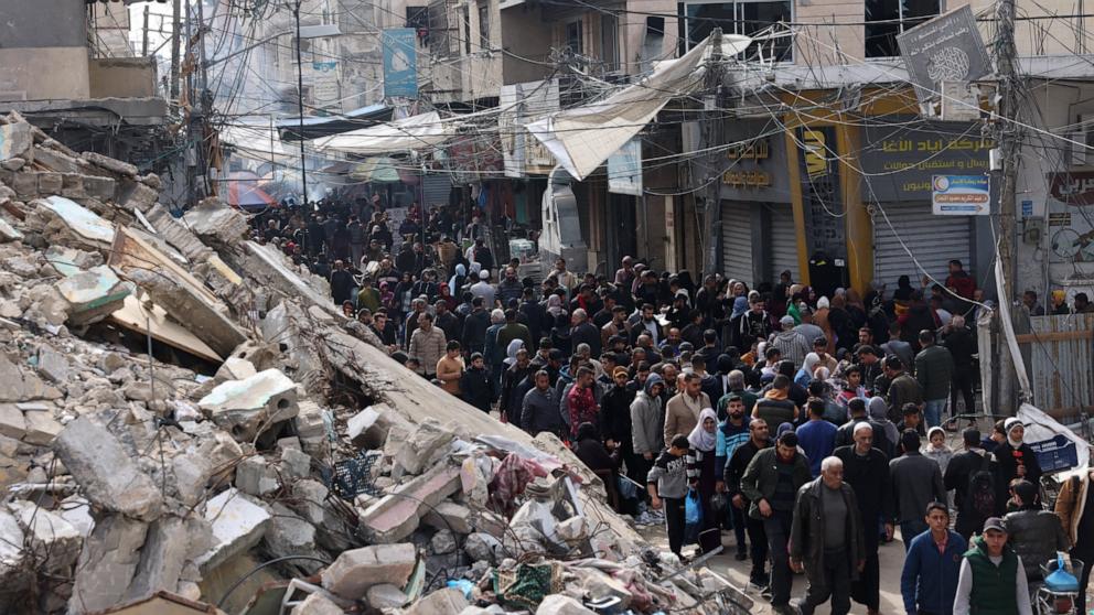 PHOTO: Crowds of locals and displaced Palestinians walk past destroyed buildings in the southern Gaza Strip city of Khan Yunis, Nov. 28, 2023.