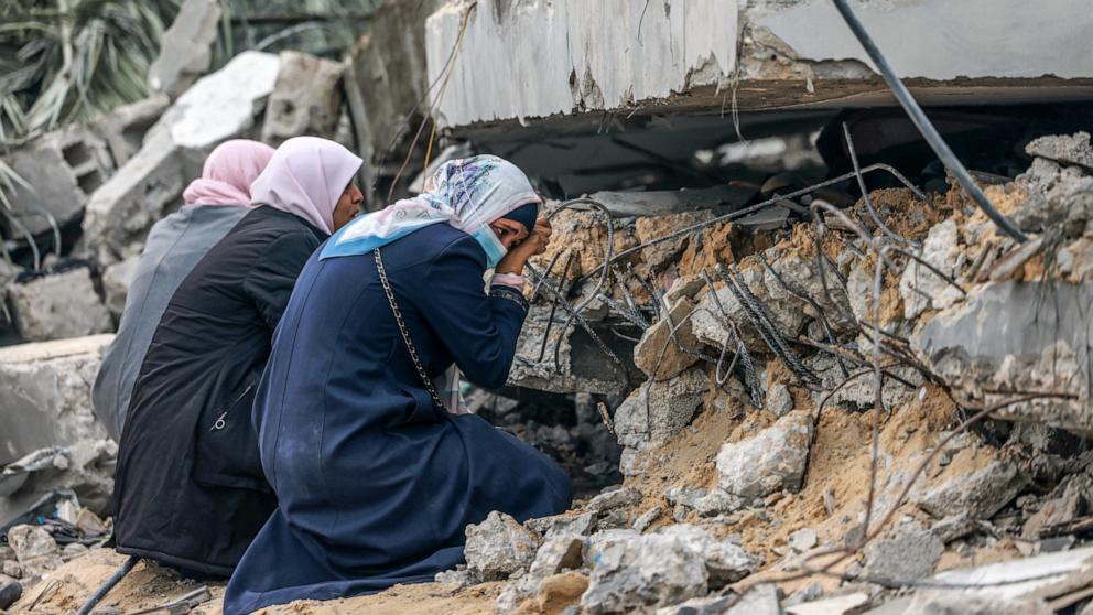 PHOTO: Palestinian women cry where a relative is believed to be trapped in debris following Israeli bombardment in Rafah in the southern Gaza Strip Dec. 21, 2023.