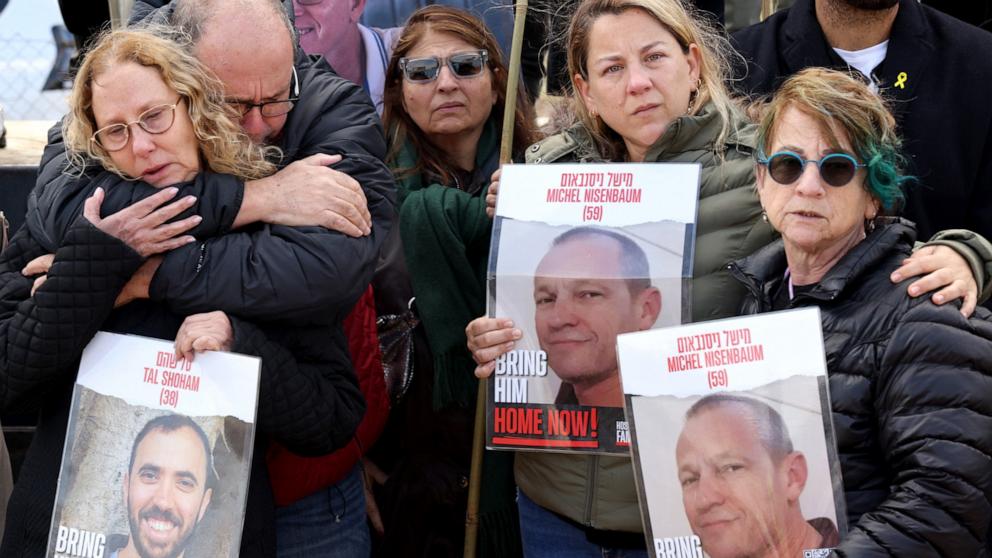 PHOTO: Relatives of Israeli hostages held by the Palestinian Hamas movement carry pictures of Michel Nisenbaum, 59 and Tal Shoham 38, in Kibbutz Nirim along the fence on the Gaza border, as their time in captivity nears to 100 days, on Jan. 11, 2024. 