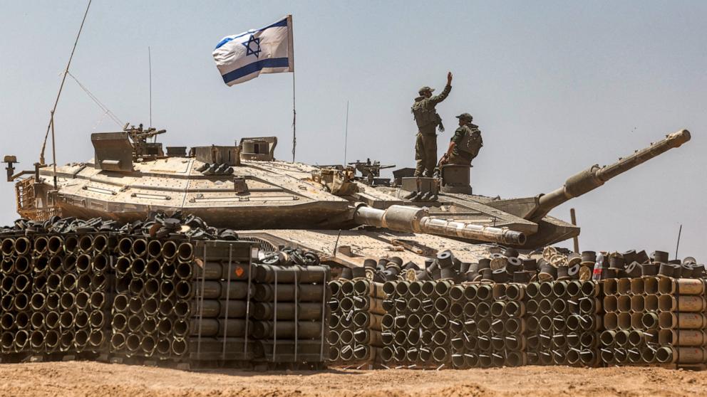 PHOTO: An Israeli army soldier gestures as he stands atop the turret of a main battle tank positioned in southern Israel near the border with the Gaza Strip on May 9, 2024.