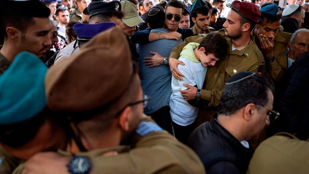 PHOTO: Family and friends of Israeli soldier Lt. Yaacov Elian mourn over his grave during his funeral at Kiryat Shaul cemetery in Tel Aviv, Israel, Dec. 22, 2023.