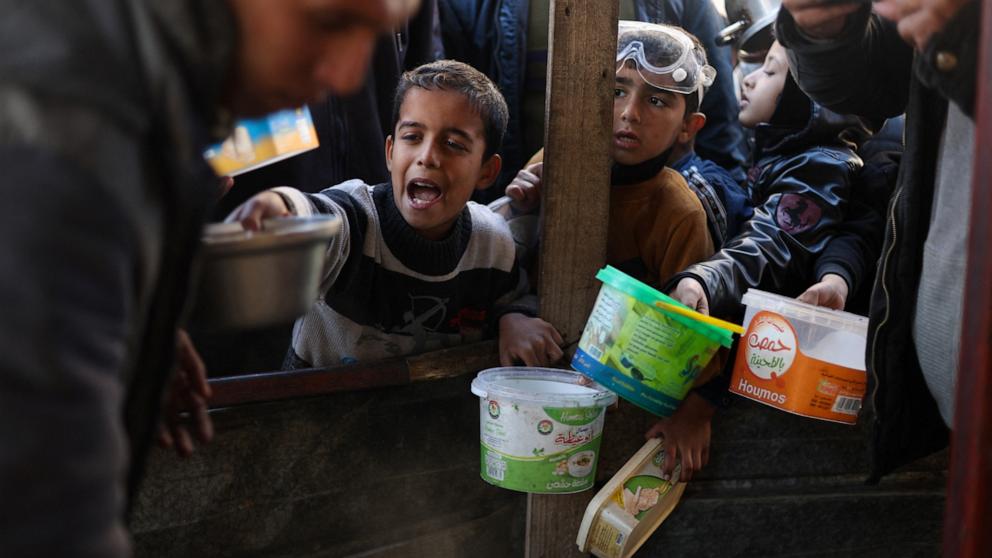 PHOTO: Palestinian children wait to receive food cooked by a charity kitchen amid shortages of food supplies, as the ongoing conflict between Israel and the Palestinian Islamist group Hamas continues, in Rafah, in the southern Gaza Strip, Feb. 5, 2024.