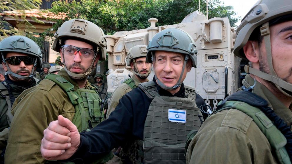 PHOTO: Israeli Prime Minister Benjamin Netanyahu, center, wears a protective vest and helmet as he receives a security briefing with commanders and soldiers in the northern Gaza Strip, Dec. 25, 2023.