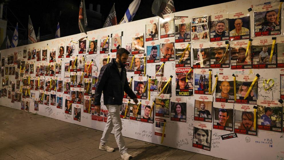 PHOTO: A man walks past portraits of Israeli hostages, held in Gaza since the October 7 attack, posted on a wall in Tel Aviv on December 15, 2023.