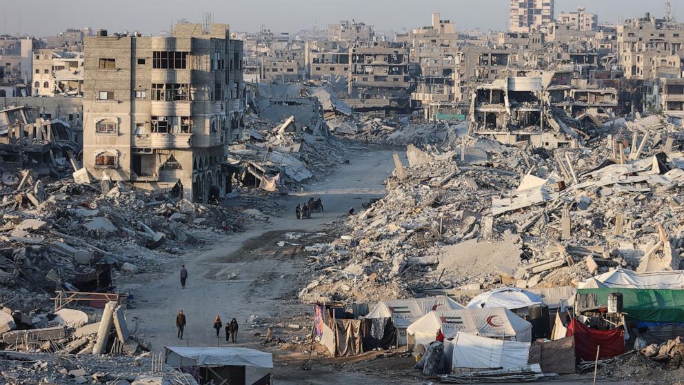 PHOTO: Palestinians walk past the rubble of destroyed buildings in the Sheikh Radwan neighborhood of Gaza City, October 22, 2025.