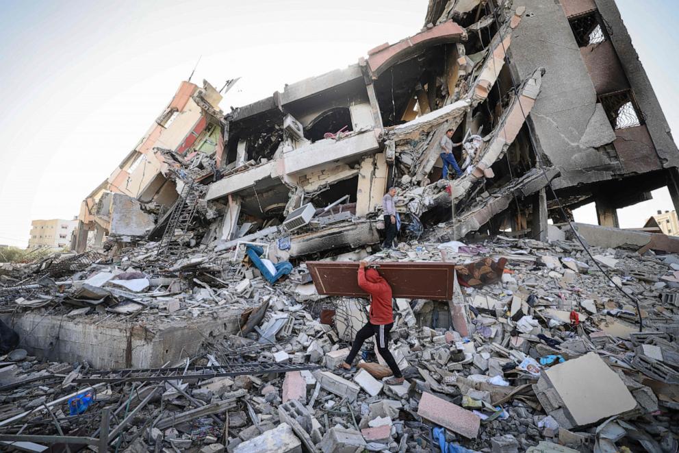 PHOTO: Palestinians carrying some belongings walk amid the rubble of destroyed buildings in Al-Zahra on the southern outskirts of Gaza City, Nov. 26, 2023.