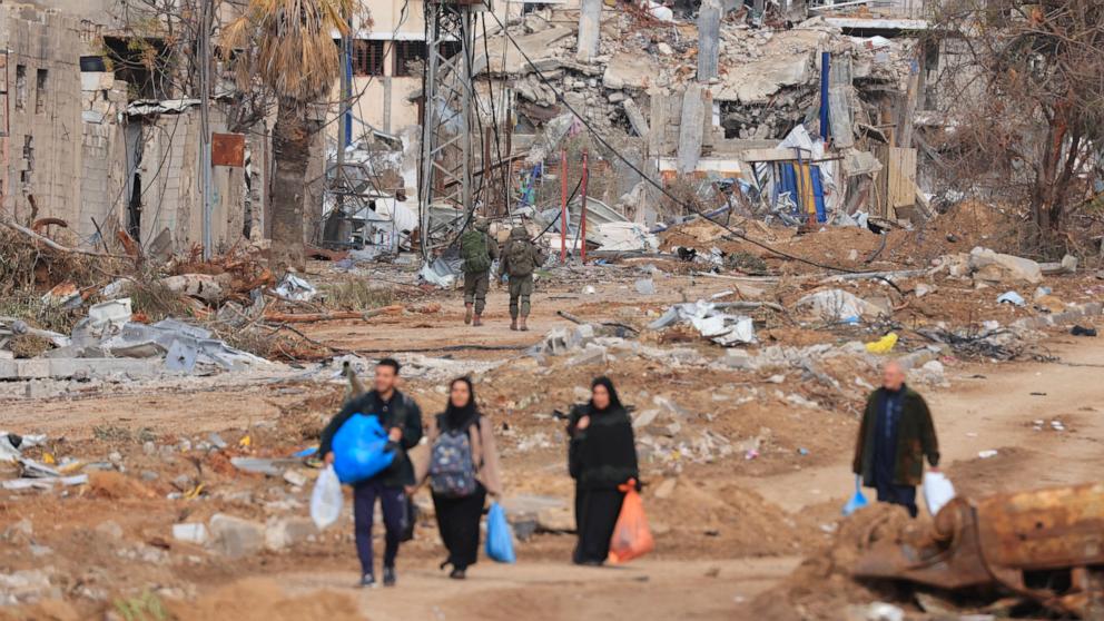 PHOTO: Israeli soldiers walk past Palestinians fleeing the north along the Salaheddine road in the Zeitoun district on the southern outskirts of Gaza City, Nov. 28, 2023.