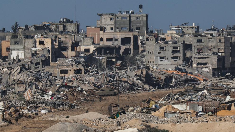 PHOTO: A picture taken from southern Israel bordering the Gaza Strip on Dec. 22, 2023, shows an Israeli army tank rolling past debris of buildings in the Gaza Strip amid ongoing battles with the Hamas militant group.  