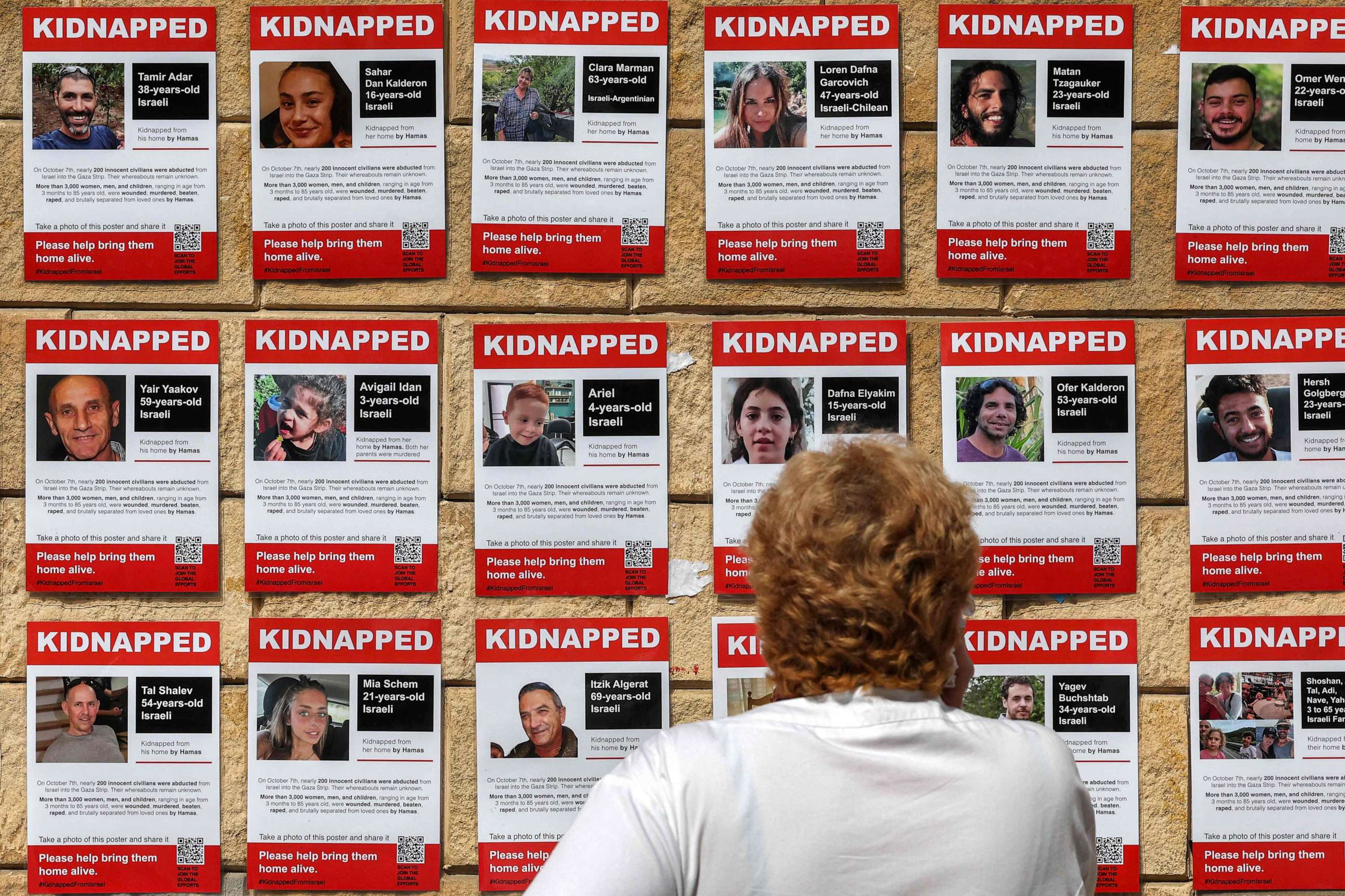 PHOTO: A woman looks at posters showing the pictures of Israeli hostages held by Palestinian militants since the Oct. 7 attack, near Azrieli Mall in Tel Aviv on Oct. 18, 2023.