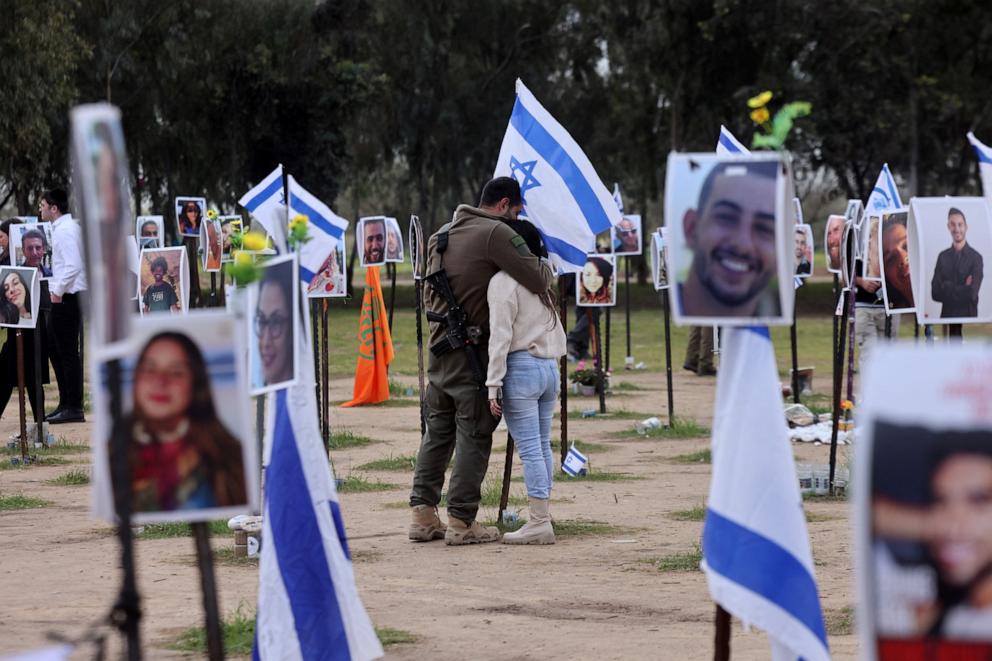 PHOTO: An Israeli soldier hugs a woman amid national flags and portraits of Israeli people taken captive or killed by Hamas militants during the Oct. 7 attacks, during a visit where the Supernova music festival took place, on Jan. 14, 2024.
