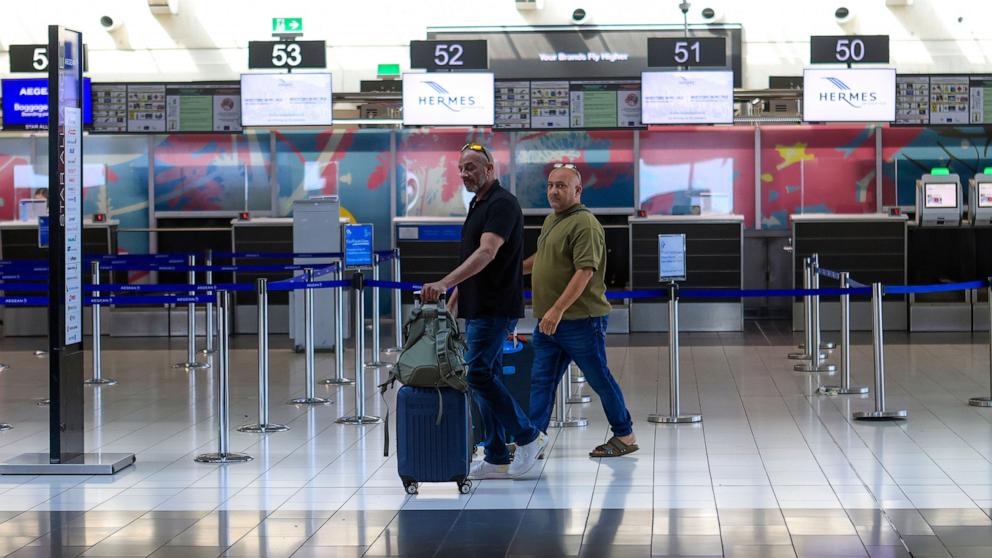 PHOTO: Israeli passengers heading for Israel's port city of Haifa walk to the check in at Larnaca International airport in Cyprus, June 20, 2025.