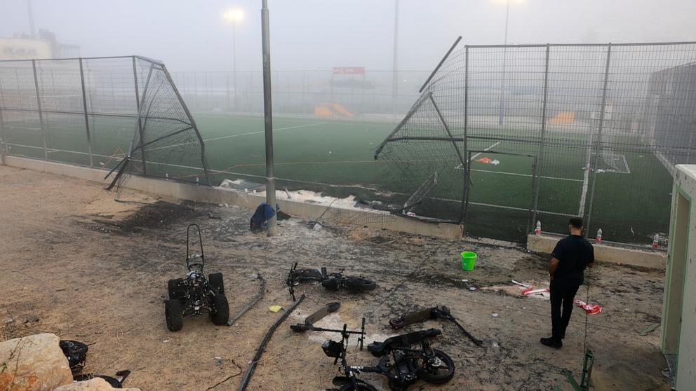 PHOTO: A man stands near a damaged gate around a football pitch after a reported strike from Lebanon fell in Majdal Shams village in the Israeli-annexed Golan area, July 28, 2024. 