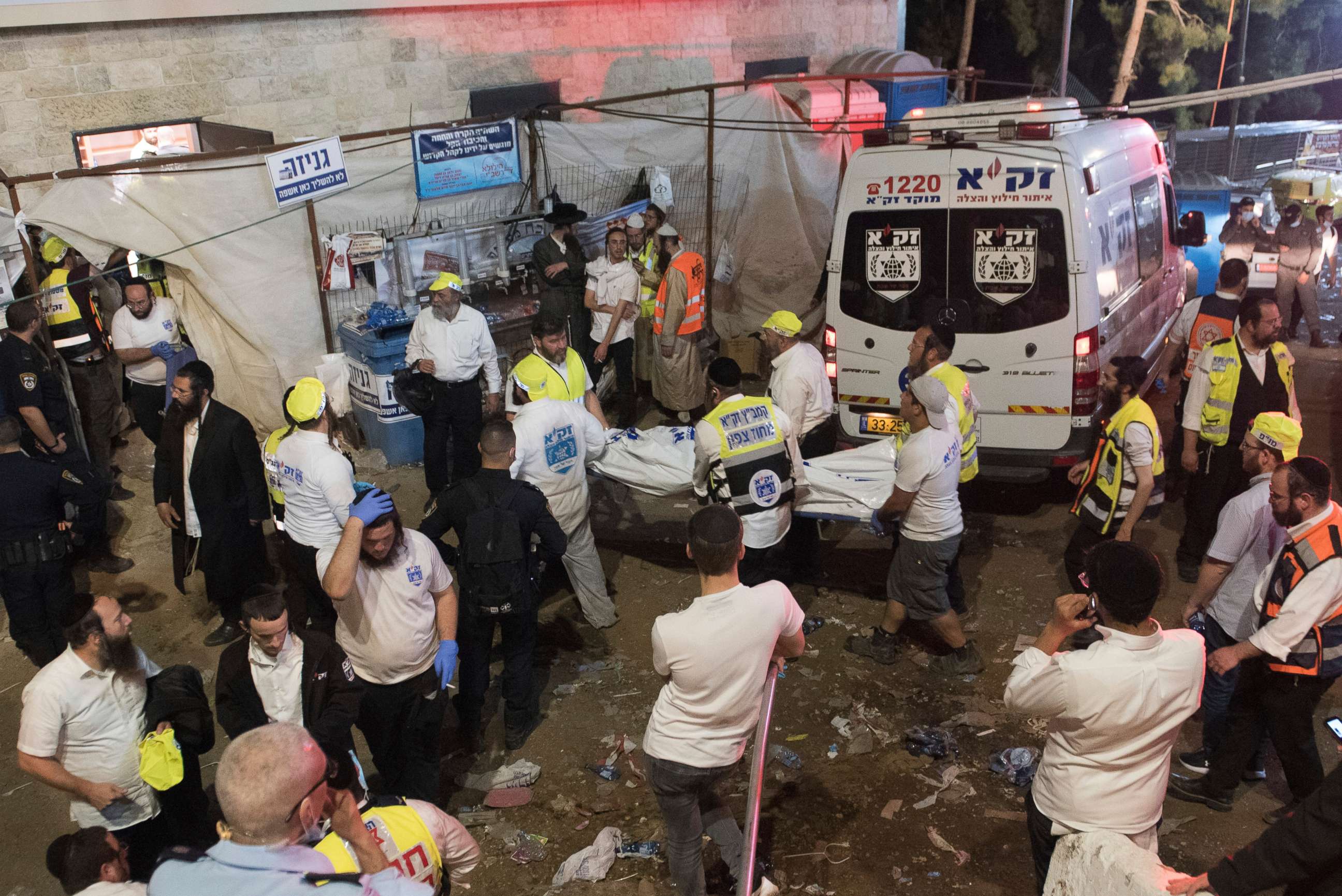 PHOTO: Israeli security officials and rescuers carry a body of a victim who died during a Lag Ba'Omer celebrations at Mt. Meron in northern Israel, Friday, April 30, 2021.