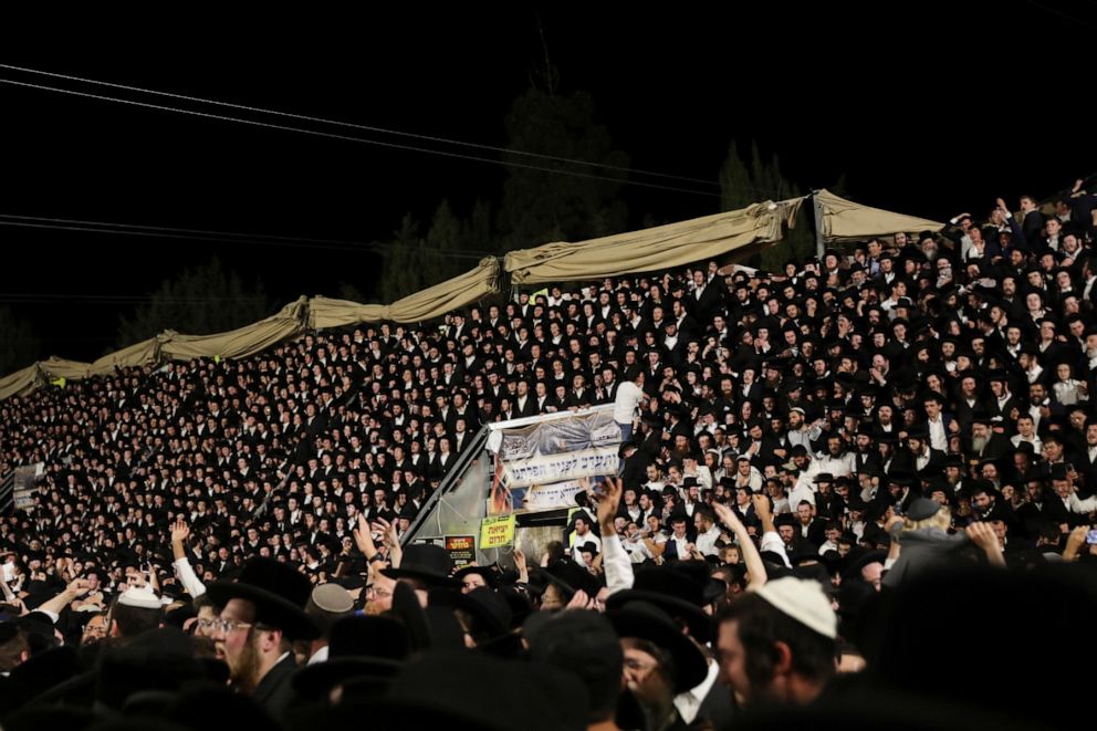 PHOTO: Jewish worshippers sing and dance as they stand on tribunes at the Lag B'Omer event in Mount Meron, northern Israel, April 29, 2021. 