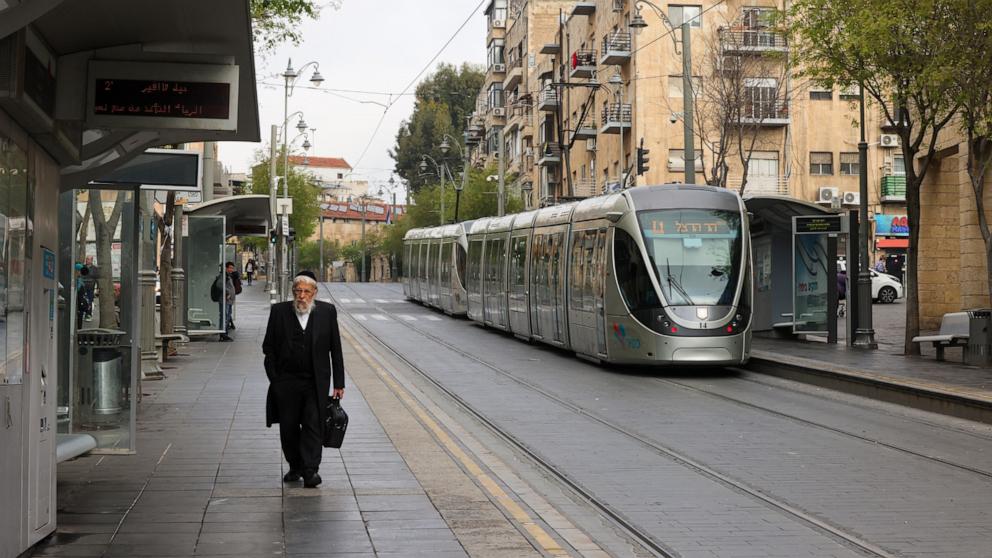 PHOTO: A man walks past a light rail train stop in Jerusalem on April 14, 2024. Iran's unprecedented attack on Israel has been "foiled," the Israeli army announced on April 14.