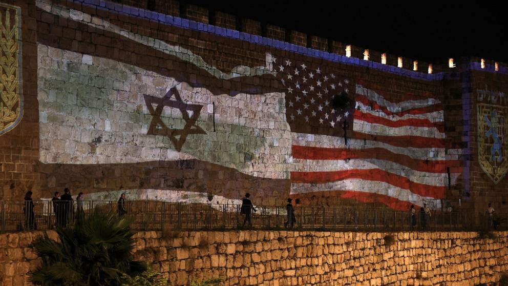 PHOTO: People walk past a projection depicting Israeli and US flags on the walls of Jerusalem's Old City on June 22, 2025.