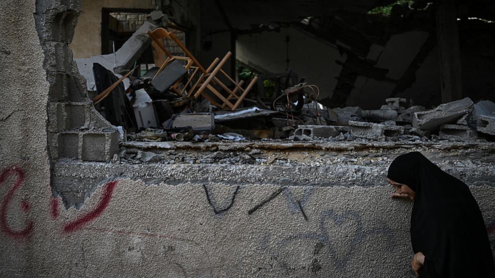 PHOTO: A woman walks near a damaged building following an Israeli military raid in the Jenin refugee camp, in the occupied West Bank, Sept. 6, 2024.