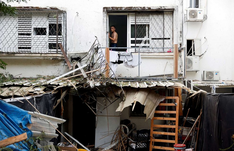 PHOTO: An Israeli man looks out from a window of a building that was hit following rockets from Gaza that were launched towards Israel in Ashkelon, southern Israel, Oct. 9, 2023.