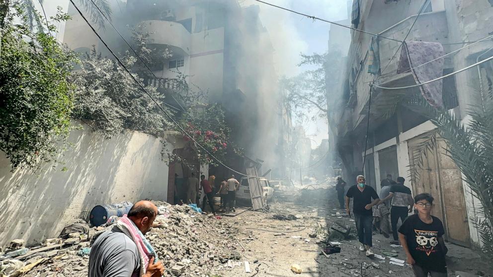 PHOTO: Palestinians walk through the rubble of destroyed buildings following an operation by Israeli Special Forces in the Nuseirat camp, in the central Gaza Strip, on June 8, 2024. 