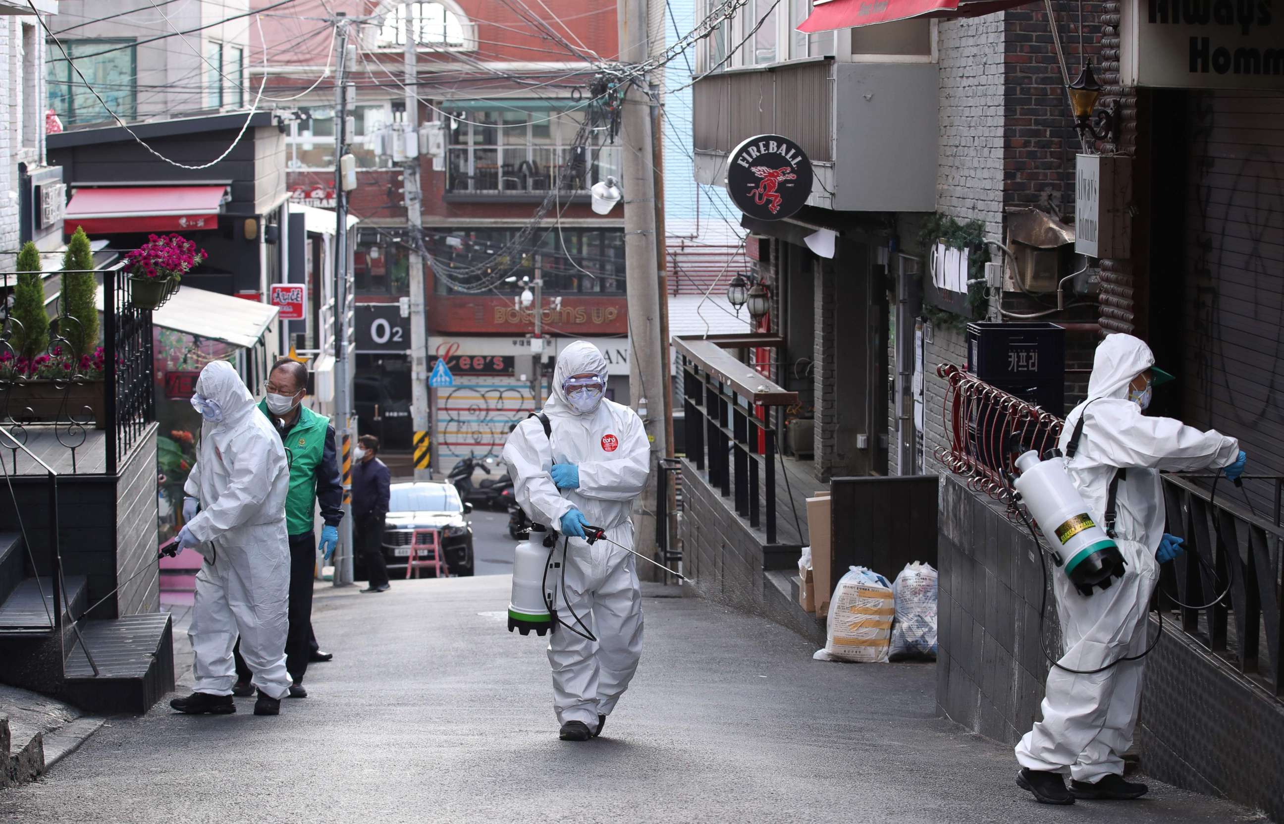 PHOTO: Health workers spray disinfectant on a street in the Itaewon district of Seoul on May 12, 2020. - South Korea's capital ordered the closure of all clubs and bars after a cluster of new cases were linked to a 29-year-old man. 