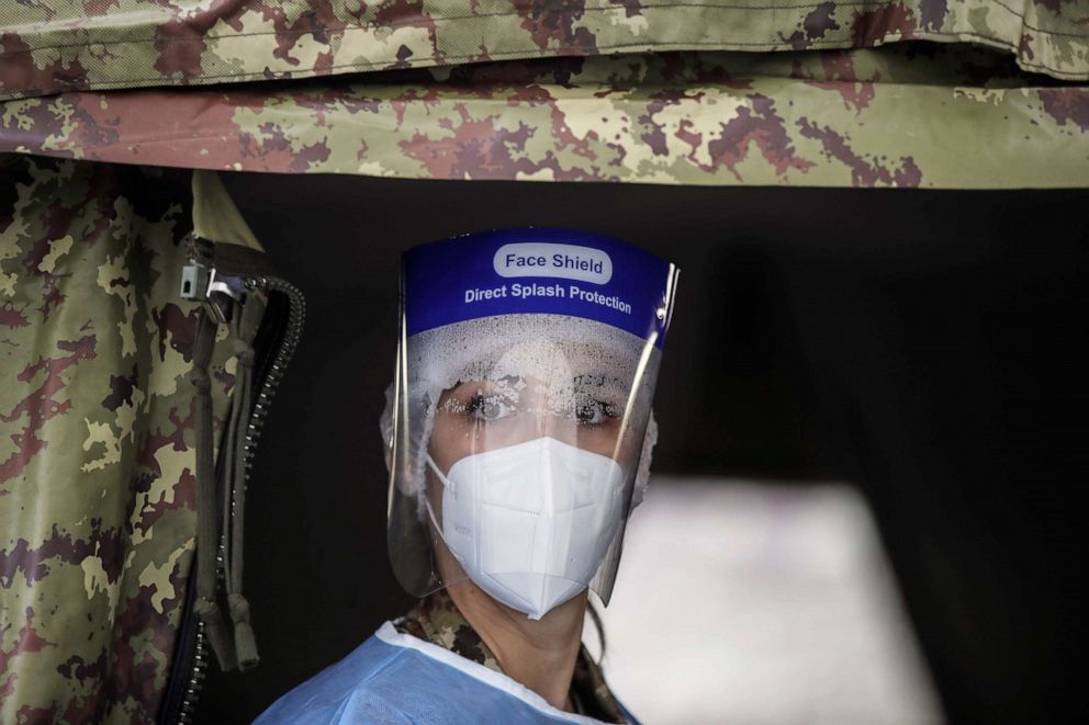 PHOTO: An Italian Army medical staff member, wearing personal protective equipment, works at a rapid COVID-19 testing area in Milan, Italy, on Nov. 13, 2020.