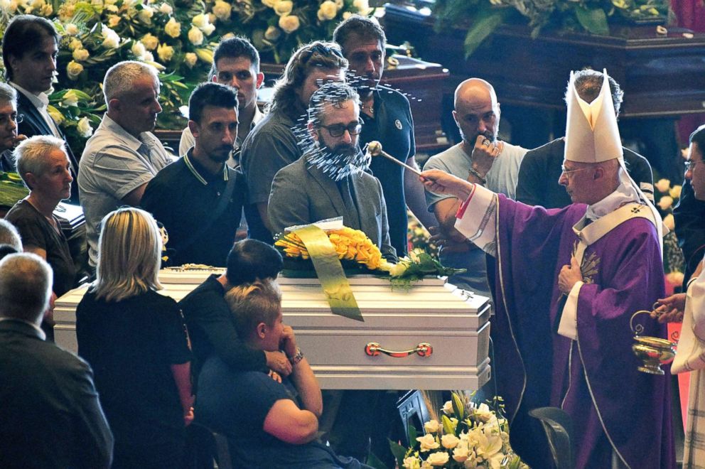 PHOTO: Archbishop of Genoa Cardinal Angelo Bagnasco (R) blesses the coffins during the state funeral of the victims of the Morandi Bridge collapse, on Aug. 18, 2018, in Genoa, Italy.