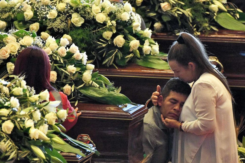 PHOTO: Relatives mourn near the coffins of some of the victims of the collapsed Morandi highway bridge, laid in front of the altar during the funeral service, in Genoa, Italy, Aug. 18, 2018.