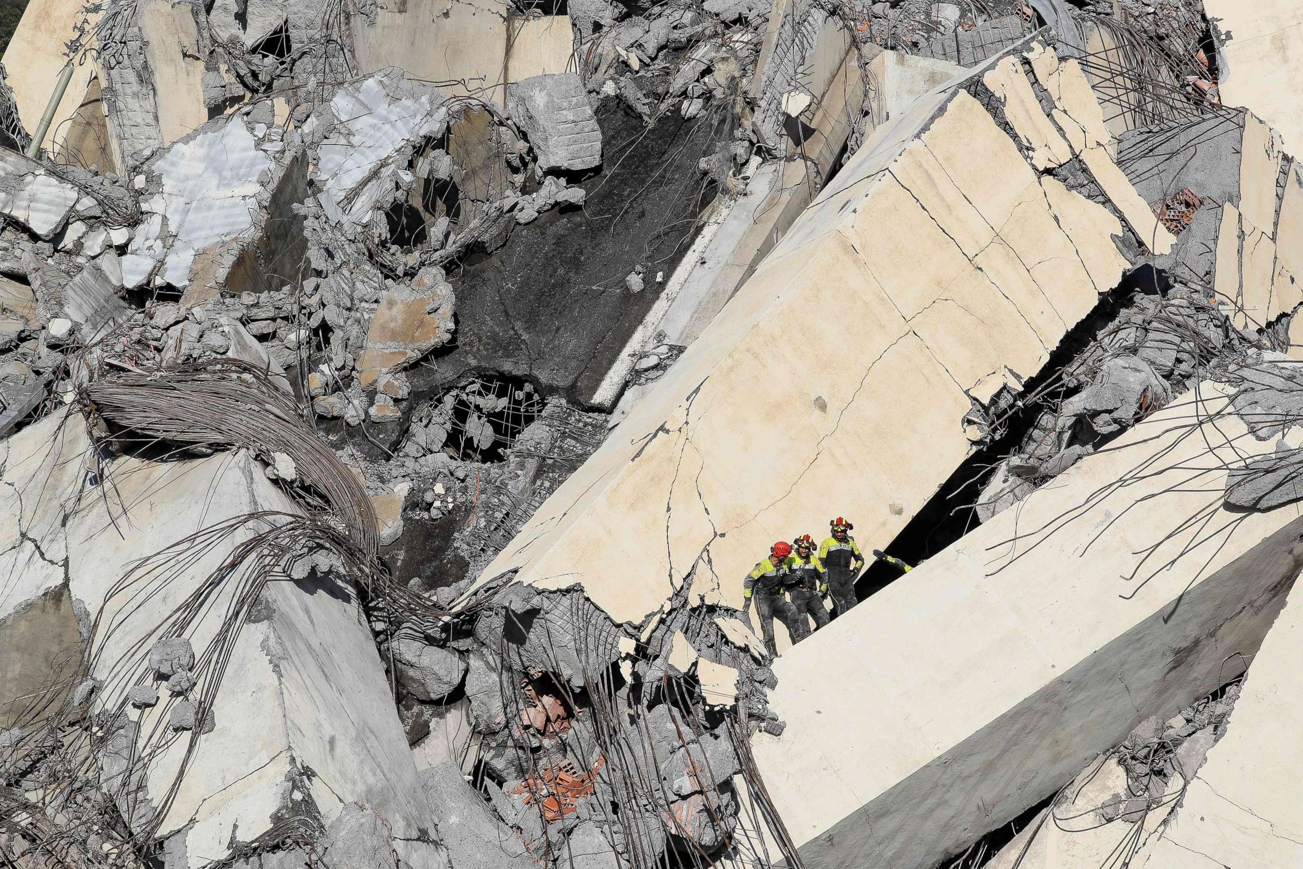 PHOTO: Italian rescuers climb onto the rubble of the collapsed Morandi motorway bridge to look for victims and survivors in the northern port city of Genoa on Aug. 14, 2018.